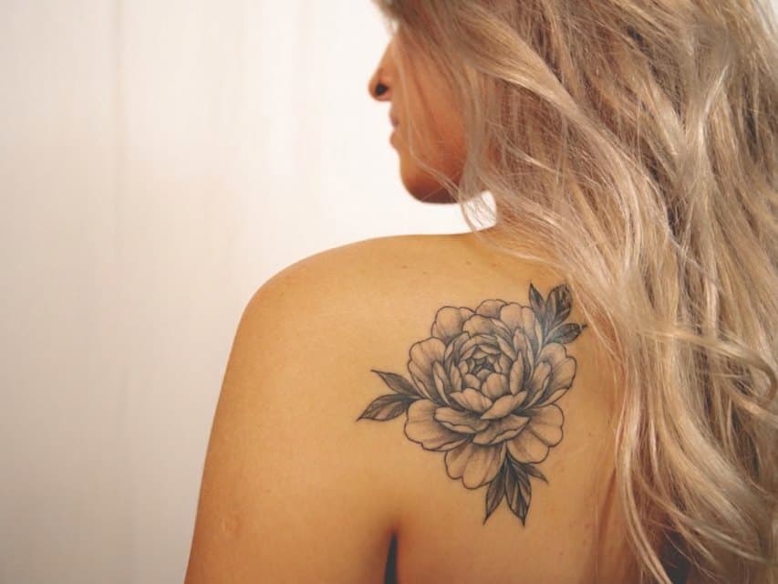 Shoulder with a black & grey peony tattoo generated by TattooAI
